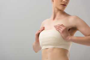 breast lift Santa Cruz CA - woman with hands on bandaged breasts